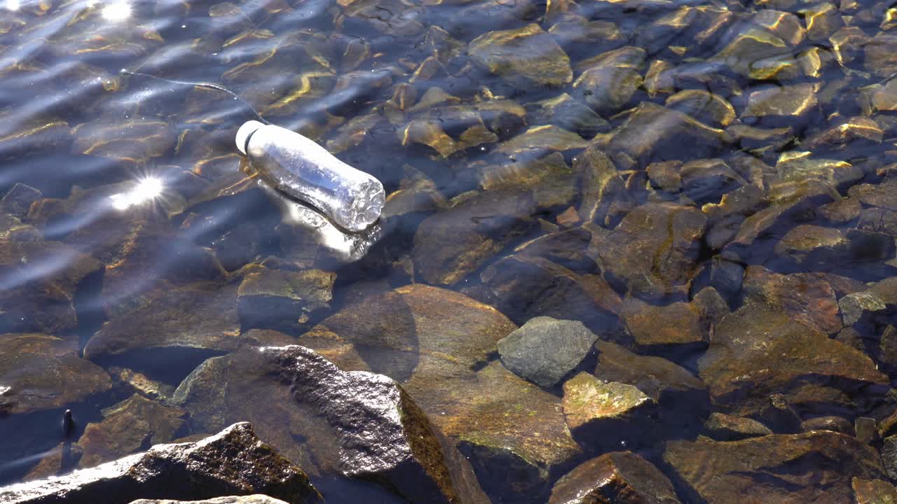 Hylätty muovipullo kelluu matalassa vedessä saastuttaen Norjan vuonoa