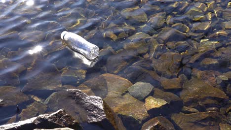 botella de plástico descartada flotando en aguas poco profundas que contaminan el fiordo noruego
