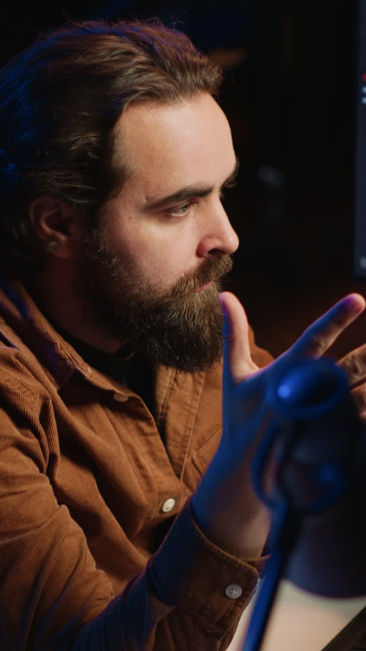 Homem barbudo relaxando e pensando em um quarto com pouca luz