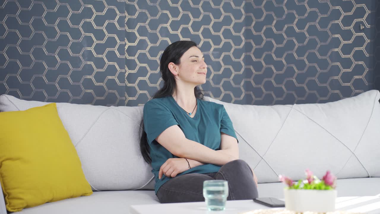 행복한 여성은 창문 밖을 바라보고 깊은 숨을 쉬고 있습니다.