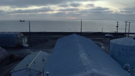 Aerial-Drone-shot-Flying-over-Flooding-Climate-Research-Center-in-the-Thawed-Permafrost-Tundra-with-Arctic-Ocean-in-Background-near-Barrow-Alaska