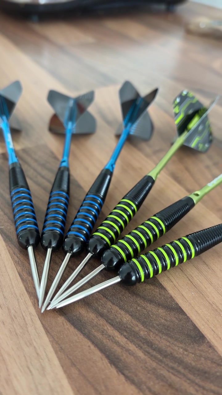 Close Up Vertical Video of Darts Grouped Together on Wooden Table