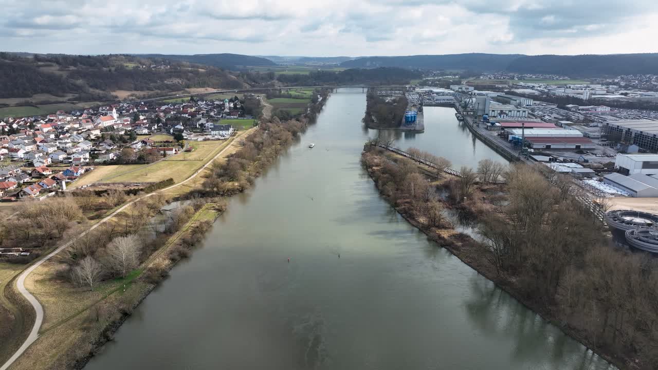 A drone shot focusing on the essential role of the Danube-Main-Canal for trade. Features a boat on the water near an industrial area