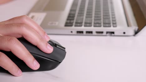 woman works at home at the computer, clicking and scrolling a computer mouse