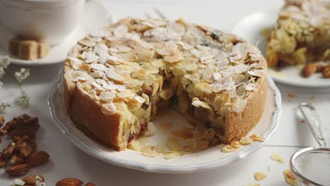 whole delicious apple cake with almonds served on wooden table