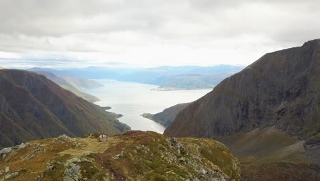 Drohnenschuss,-Der-über-Einen-Berg-In-Norwegen-Fliegt-Und-Einen-Wunderschönen-Fjord-Darunter-Enthüllt