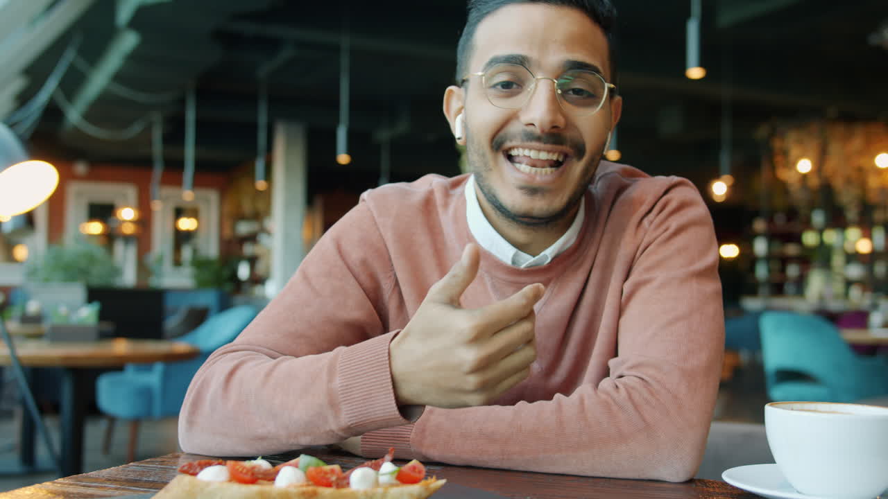 hombre haciendo una llamada de video en un café