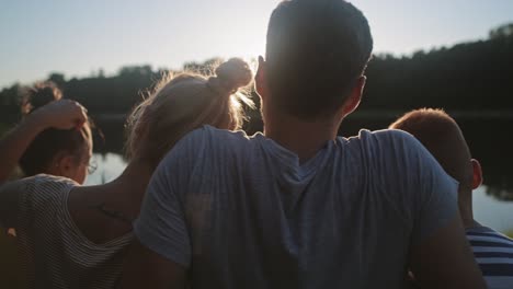 Seguimiento-Del-Video-De-La-Derecha-De-Una-Familia-Viendo-La-Puesta-De-Sol-Junto-Al-Lago.