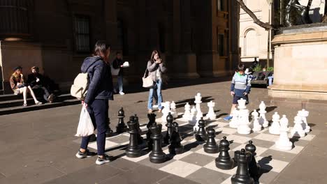 people playing giant chess outside library