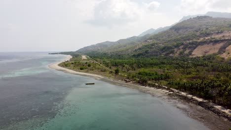 Rising-over-remote-tropical-island-coastline-with-crystal-clear-turquoise-water-and-small-rural-runway-landing-strip-in-the-distance