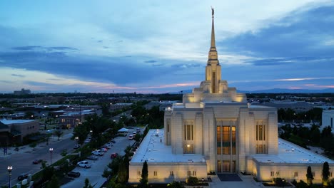 Templo-Mormón-Lds-En-Ogden,-Utah,-Vuelo-De-Drones-Volando-Al-Atardecer-En-Una-Hermosa-Noche-De-Verano-Mientras-La-Cámara-Se-Mueve-De-Izquierda-A-Derecha-Y-Alrededor-Del-Lado-Del-Edificio-Religioso-Dorado-Por-La-Noche