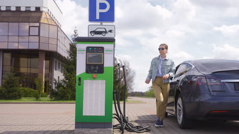 Young-woman-getting-of-an-electric-car