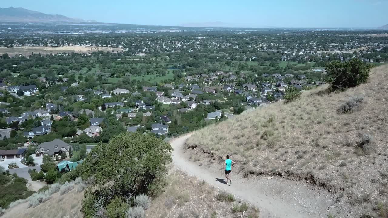 드레이퍼 시티, 유타-1 위의 야외 산길에서 활동적인 남자를 따라 드론 샷