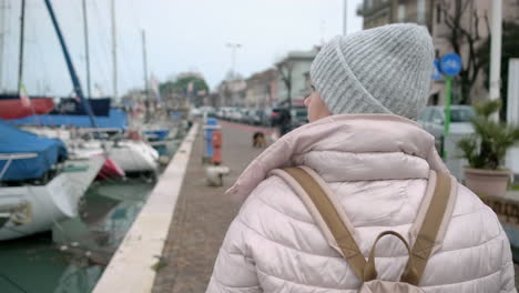 woman walking along a city port in winter