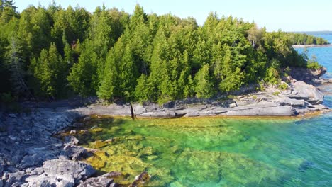 Aerial-view-rocky-shore-and-crystal-clear-lake-water-in-Georgian-Bay,-Ontario,-Canada