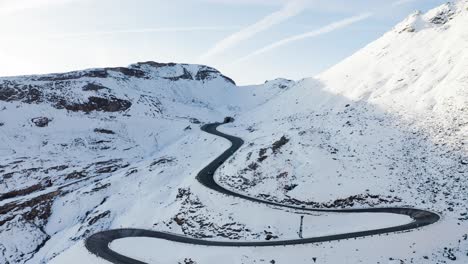 Una-Increíble-Vista-Aérea-De-Una-Carretera-Sinuosa-En-Las-Montañas-Nevadas