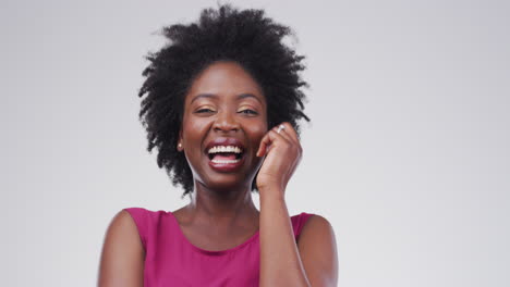 a-young-woman-laughing-against-a-gray-background