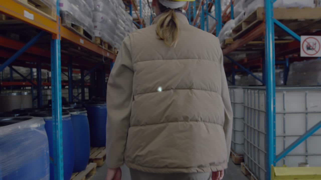 Warehouse inspector wearing helmet walking initiating digital IoT network overlay linking shelves