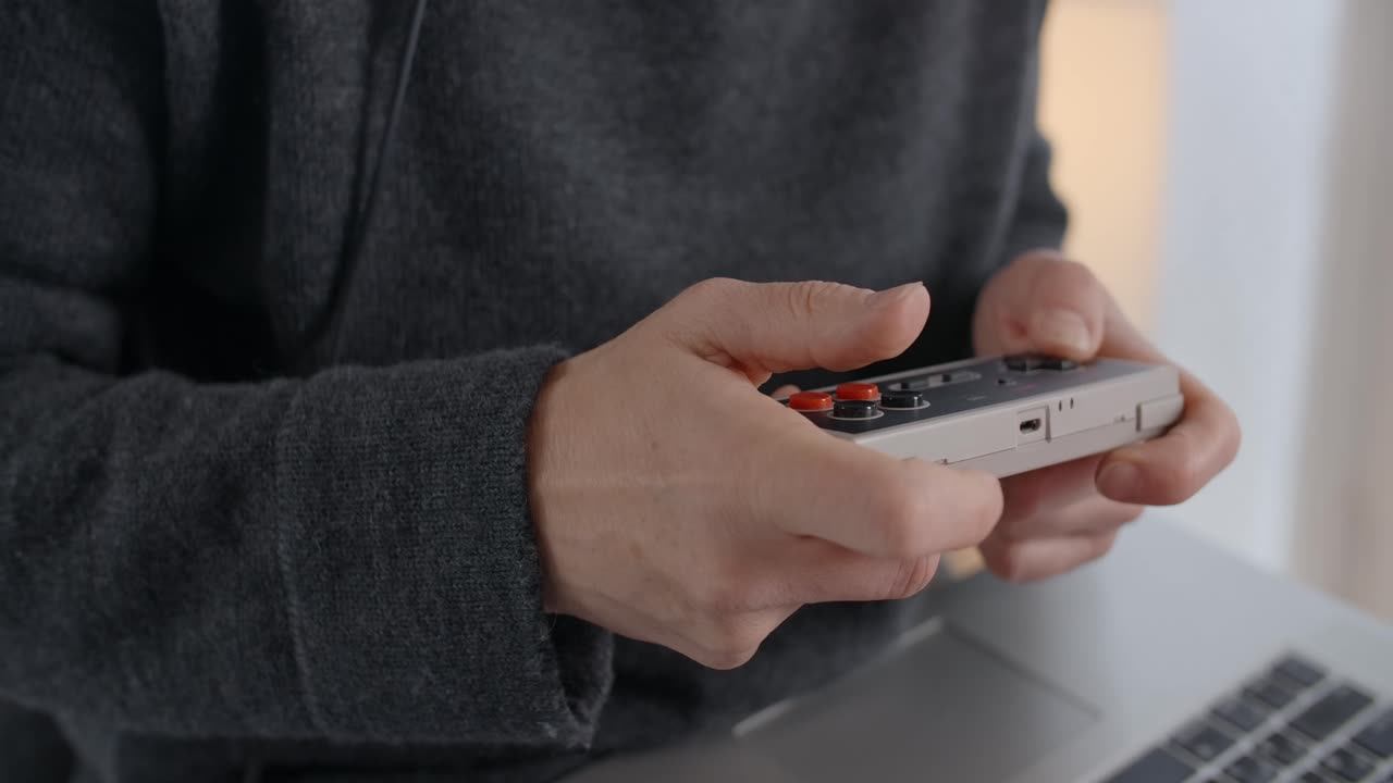 Person playing a vintage video game controller