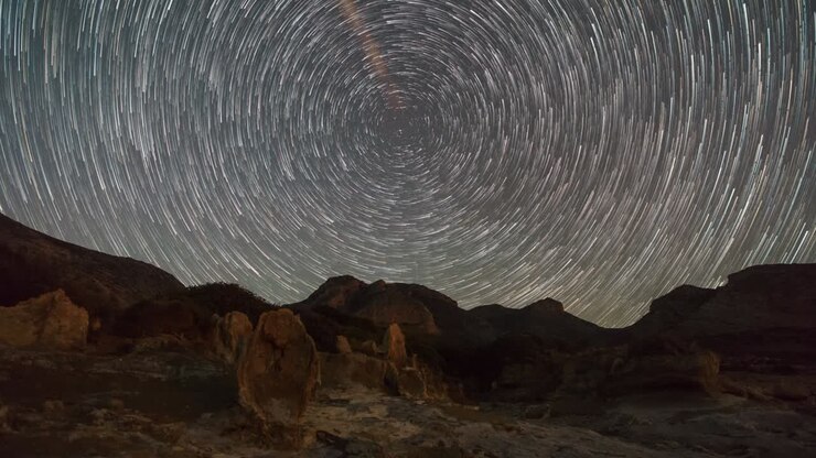 Moving stars making a circle of star trails with polaris in centre over stone forest Geopark Agios Nikolaos with fossilized tree trunks, Peloponnese, Greece