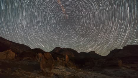 moving stars making a circle of star trails with polaris in centre over stone forest geopark agios nikolaos with fossilized tree trunks, peloponnese, greece