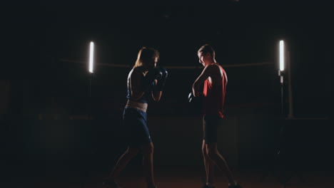 Mujer-Adulta-Joven-Haciendo-Entrenamiento-De-Kickboxing-Con-Su-Entrenador.