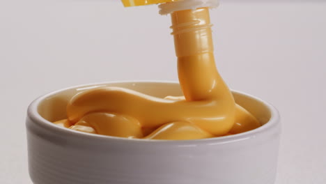 cheese sauce pouring into a bowl