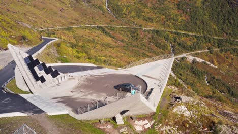 vista aérea, mujer solitaria en el punto de vista moderno sobre el valle de gualarfjellet noruega en un día soleado de verano, disparo de drones en órbita