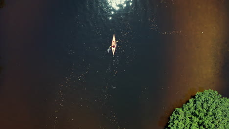 flying above lone female kayaker unveiling tropical river