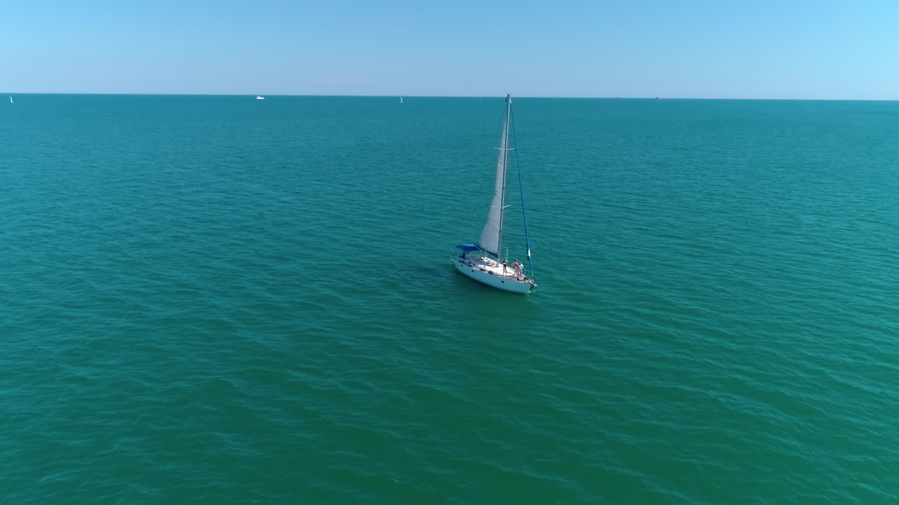 Aerial view of yacht holding at the sea. Young group of people dancing at the yacht.