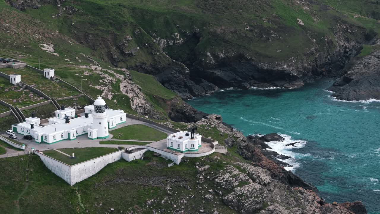 Retreating circle left drone overview from Pendeen Lighthouse out toward open ocean, aerial