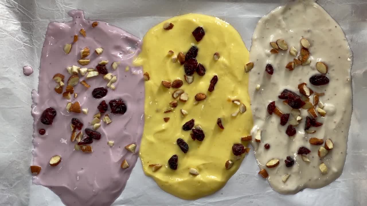 Womans hand putting raisin over Indian yogurt