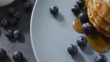 Video-of-pancakes-on-plate-seen-from-above-on-wooden-background