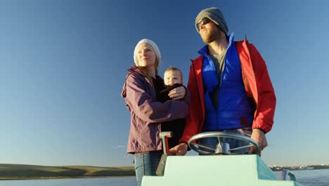 parents with baby travelling in motorboat 4k