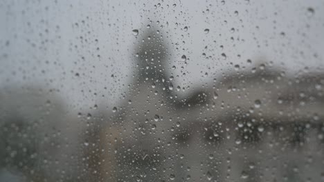 gloomy and overcast weather, a narrow focus view of rainy glass as rain drops are seen on a window