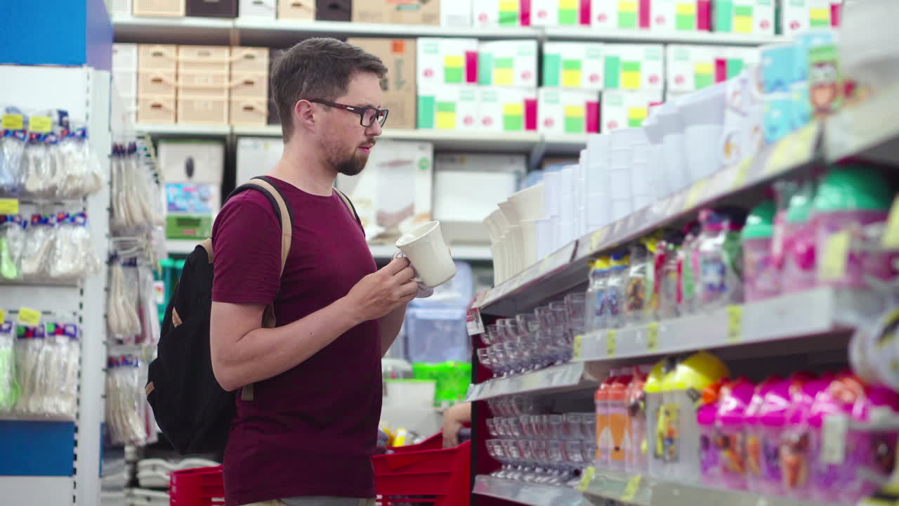 hombre comprando tazas y utensilios en una tienda
