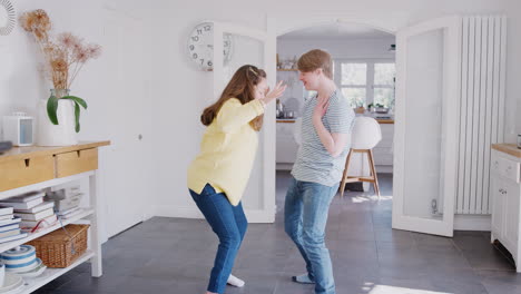 una pareja joven con síndrome de down que se divierten bailando juntos en casa.