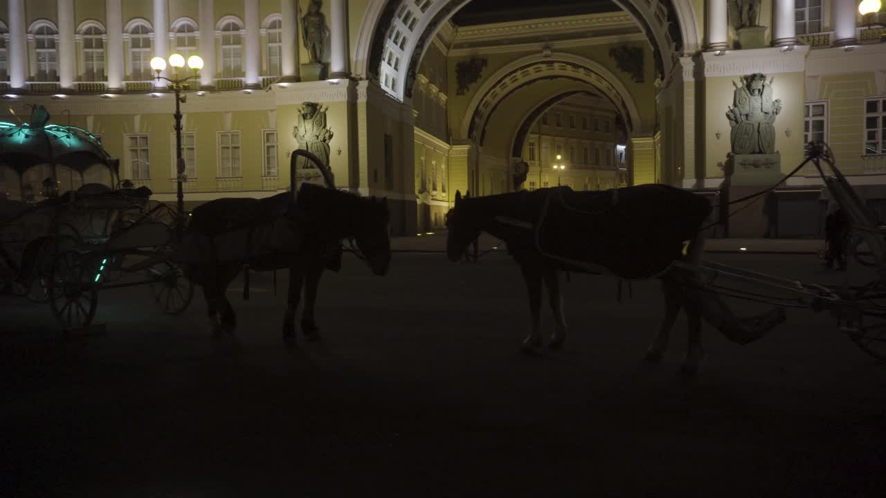 caballos y carruajes frente al palacio de invierno por la noche