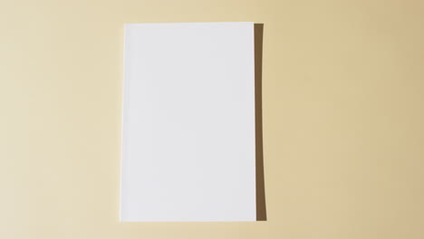 Video-of-book-with-blank-white-pages-and-copy-space-on-yellow-background