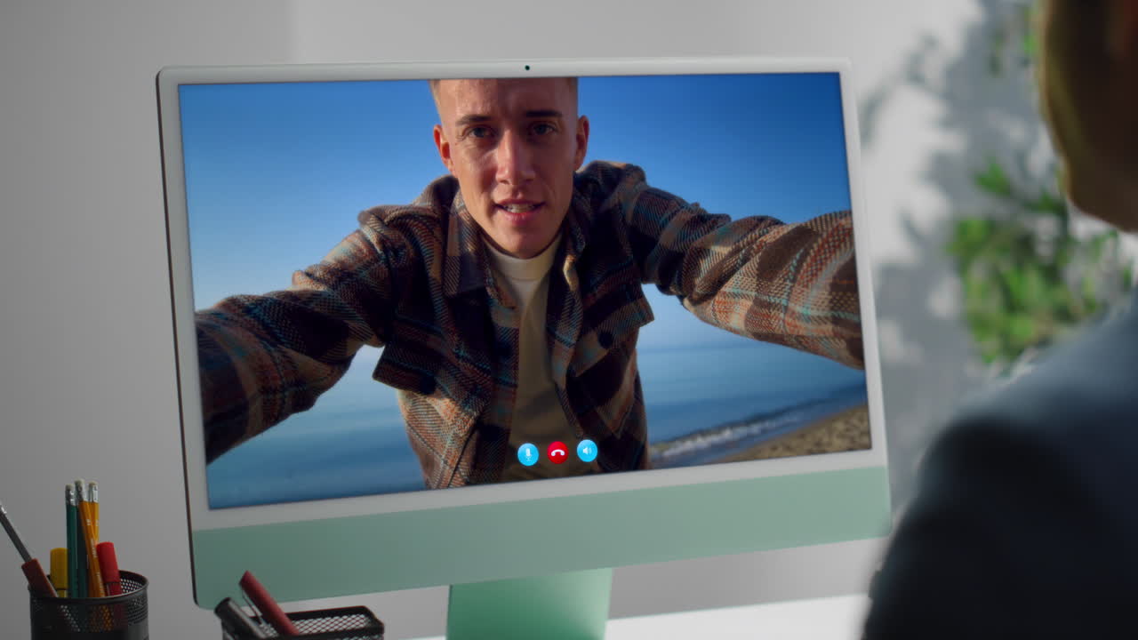 Young man on a video call with a beach backdrop