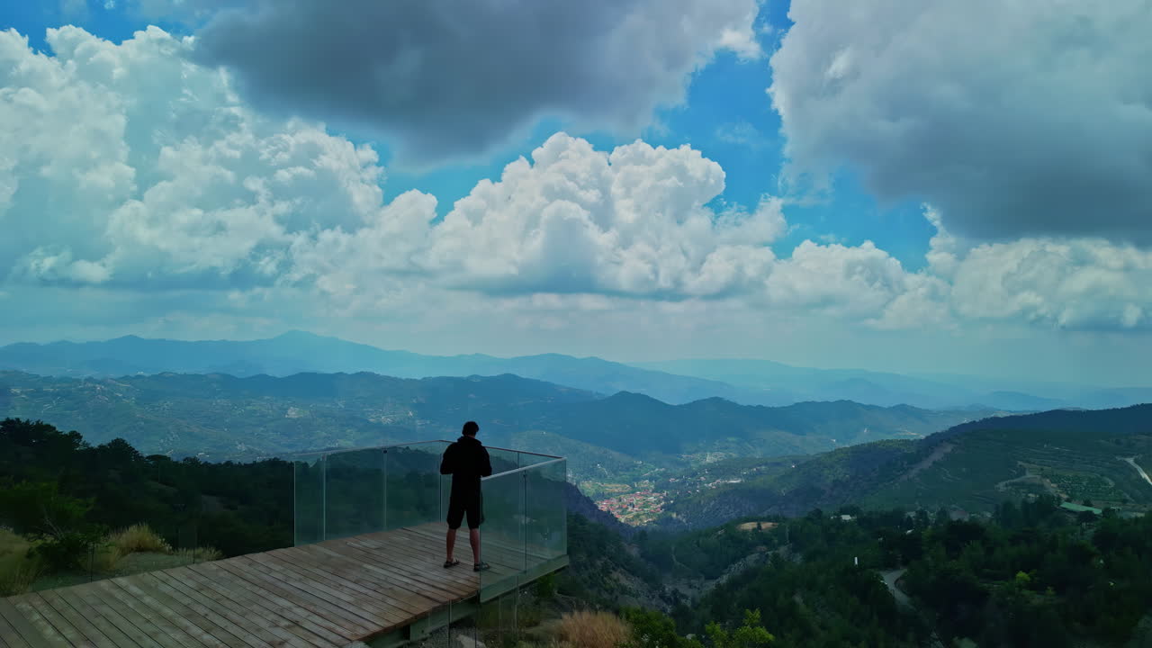Aerial drone bird's eye view of a man looking at a Valley from a viewpoint