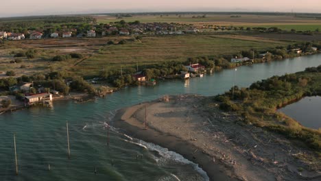 aerial shot of the valleys near ravenna where the river flows into the sea with the typical fishermen's huts