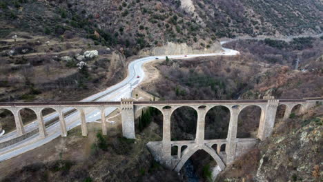 Vista-Aérea-Del-Puente-Séjourné-Que-Pasa-Por-Encima-De-Una-Autopista-Y-Un-Acantilado-En-Fontpédrouse,-Francia