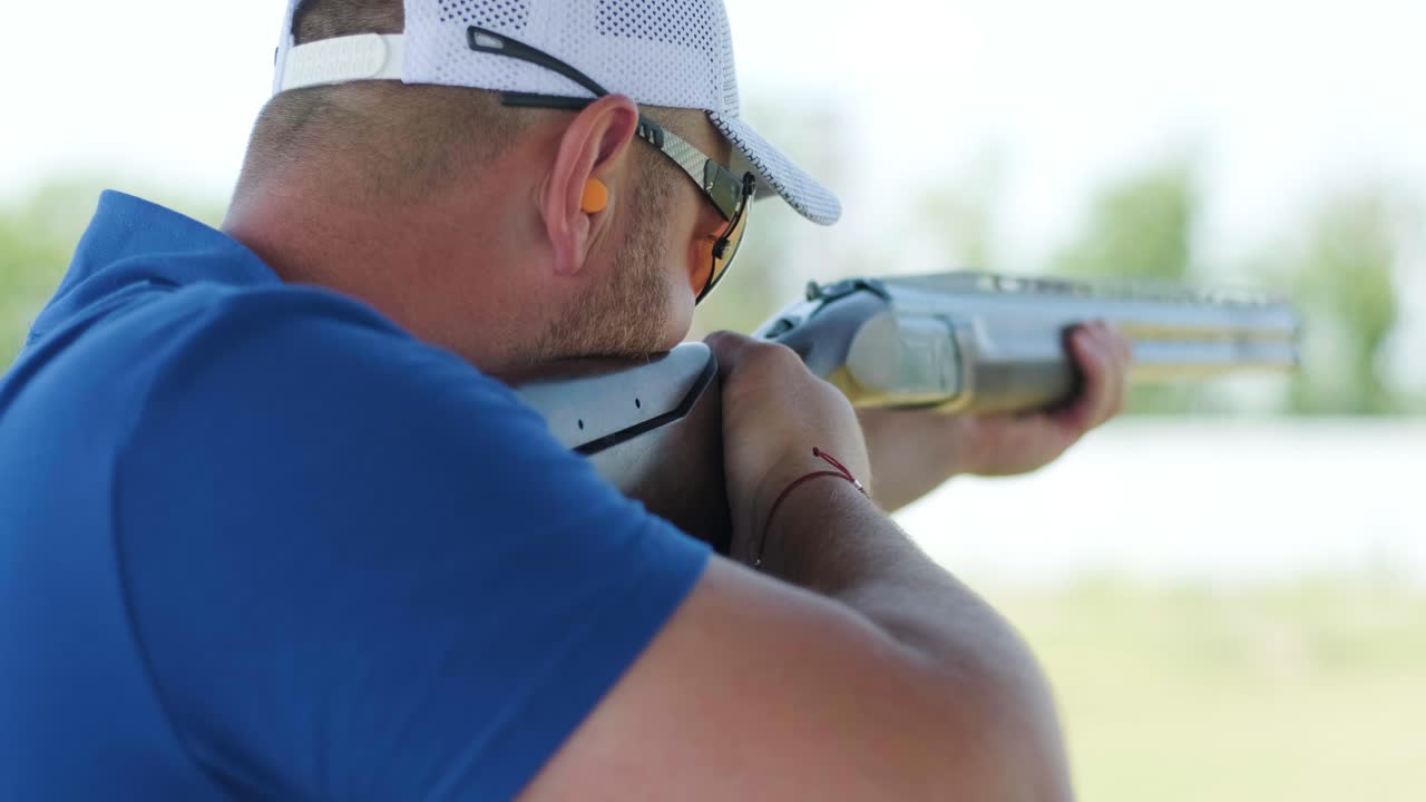 un deportista dispara con una escopeta de doble cañón, un campo deportivo para una prueba de tiro está disparando a un esquete volador