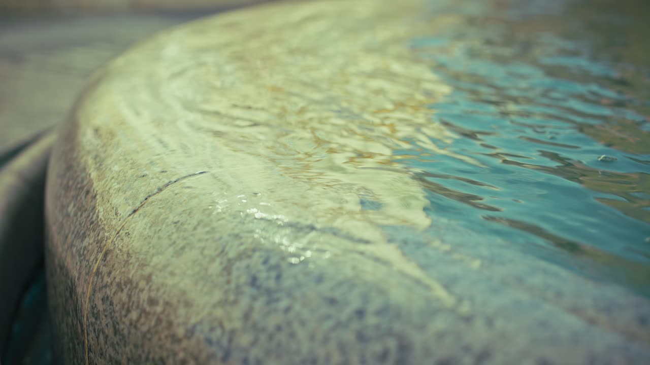 Close up of rippling water flowing over the edge of a Manduševac fountain in Josip Jelačić Square, Zagreb