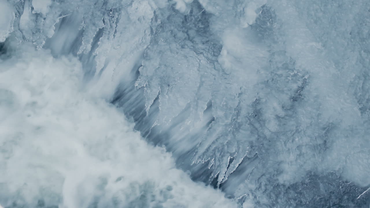 Winter waterfall. Transparent icicles. Water falling. Transparent ice surface