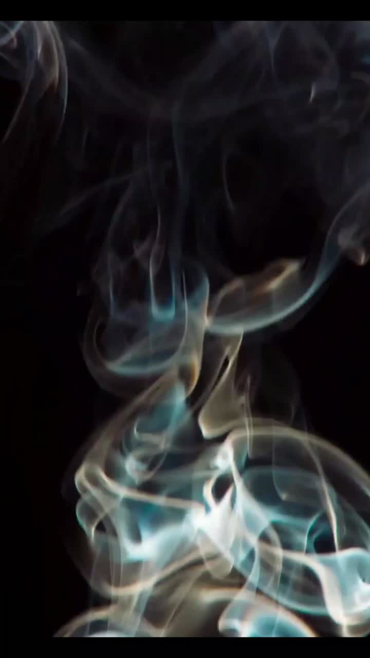 Fumo colorato che sale e vortica su sfondo nero