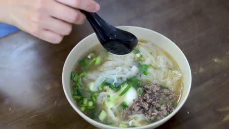 person enjoying a bowl of pho