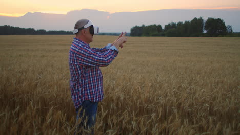 Una-Granja-De-Ancianos-Usa-Un-Casco-Vr-Mientras-Está-De-Pie-En-Un-Campo-Al-Atardecer.-Utilice-Gestos-Para-La-Realidad-Virtual-En-La-Agricultura.