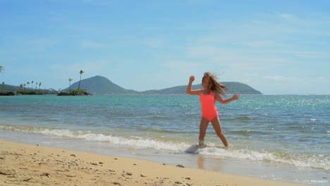 chica jugando en el agua en la playa 4k